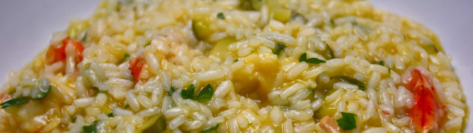 Cremiges Risotto mit Shrimps – Feine italienische Spezialität Teller mit cremigem Risotto, garniert mit saftigen Shrimp-Stücken, auf weißem Hintergrund präsentiert – ein elegantes und schmackhaftes Gericht für Genießer.