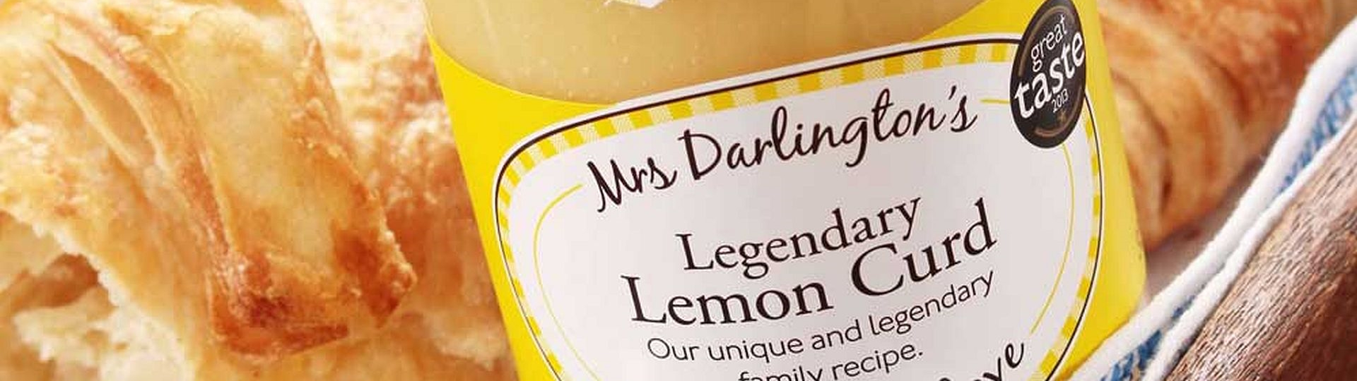 Ein Glas Mrs. Darlington's Legendary Lemon Curd vor leckeren Croissants